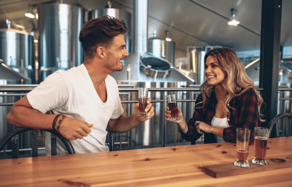 guy and girl drinking in the top Scottsdale breweries sharing a laugh and beer.